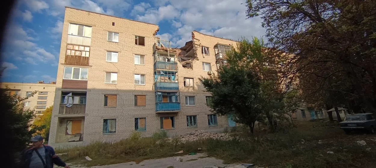 П'ятиповерхівка у Слов'янську - зверху діра від обстрілу, вікна забиті фанерою, навколо уламки