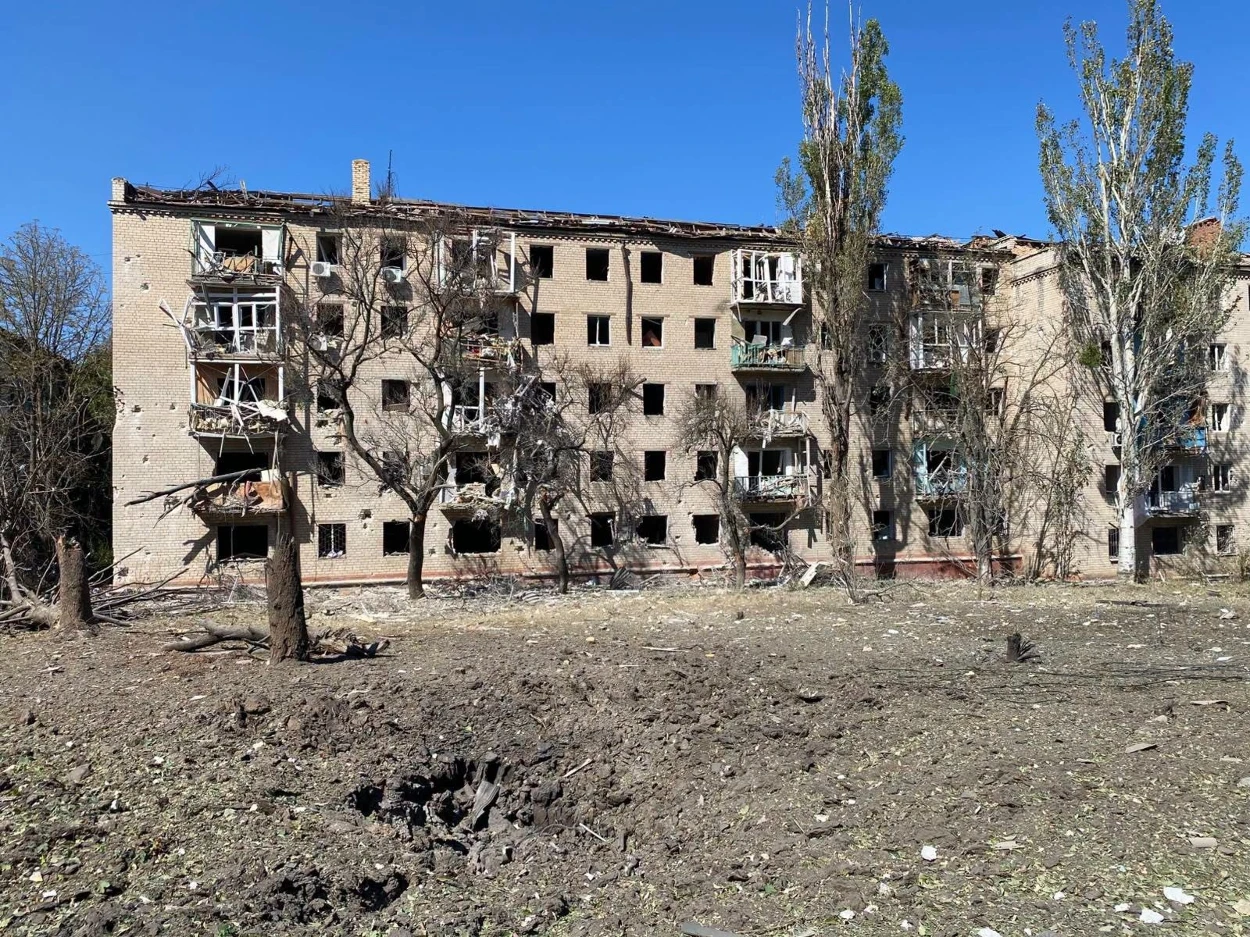 Пошкоджена авіаударом багатоповерхівка у Краматорську. Перед будинком — вирва, уламки та зламані дерева.