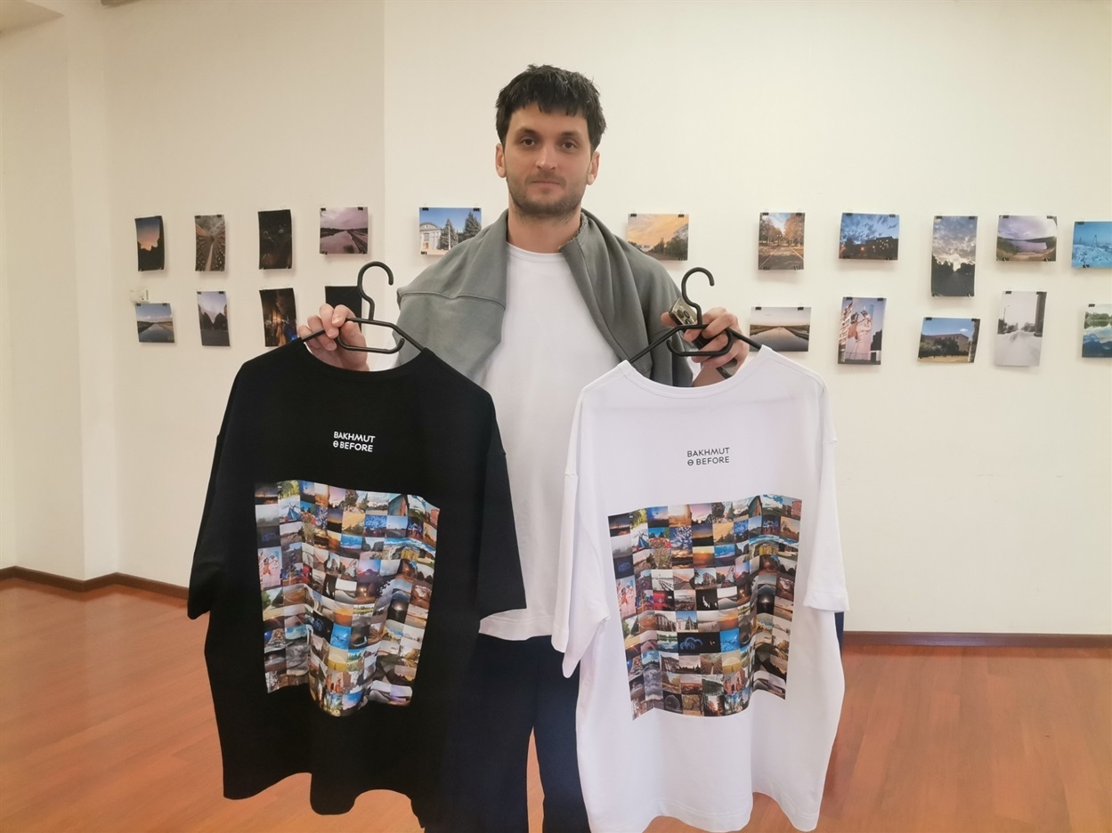 На виставці можна було придбати футболки зі світлинами Бахмута, які тримає Олексій Халтурін