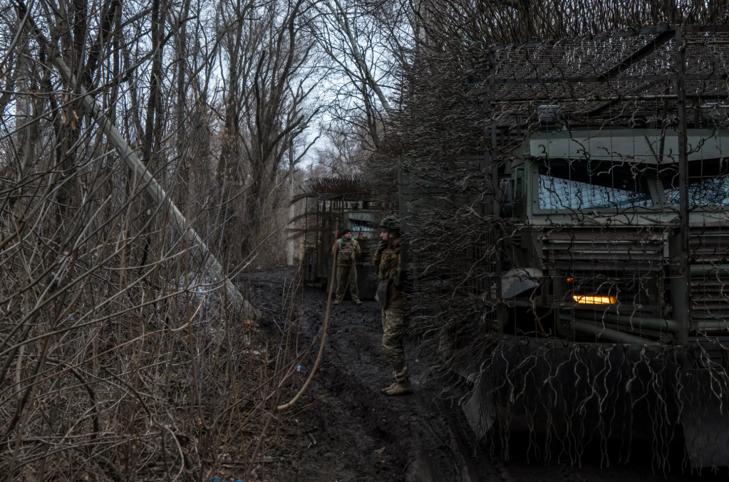 Українські військові біля замаскованої військової техніки в Донецькій області
