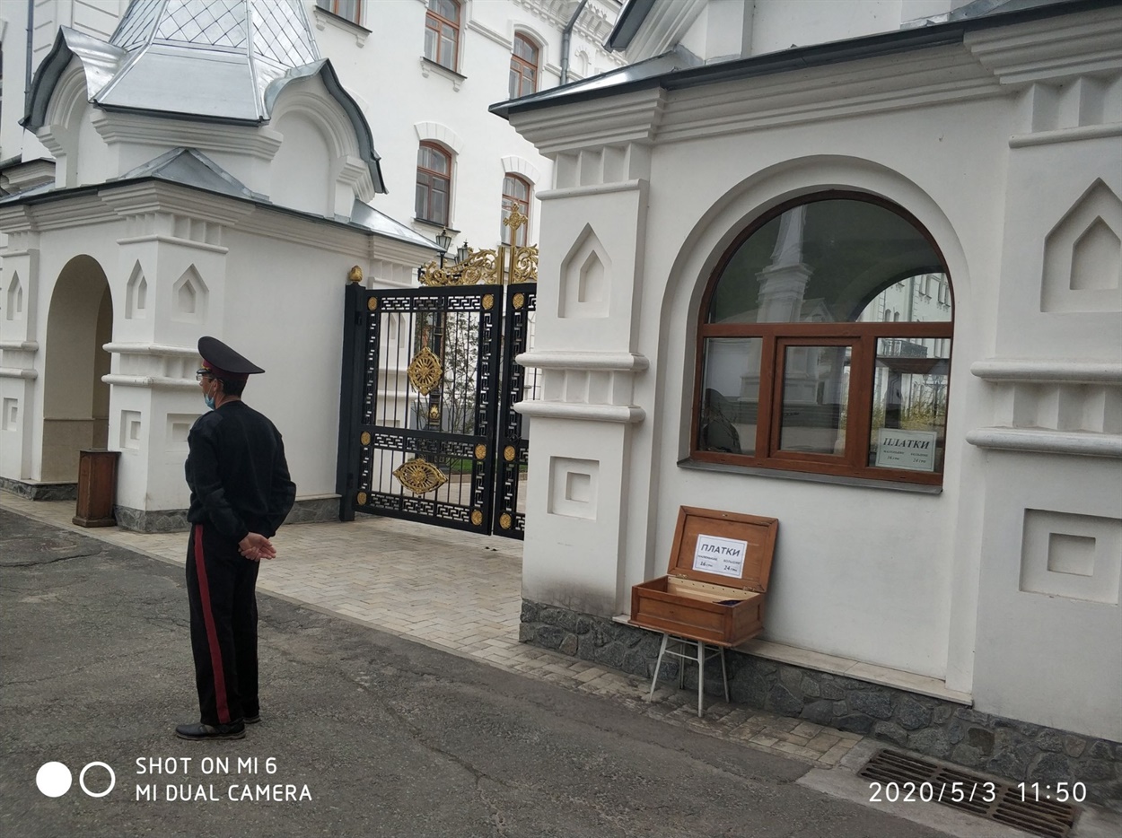 Козачок на вході до Святогірської лаври пильнує, щоб усі жінки були в спідницях