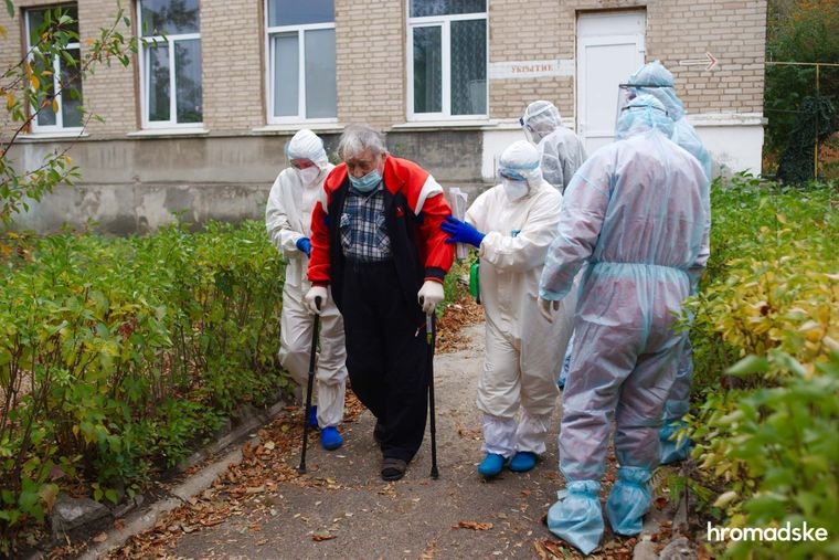 Медперсонал веде пацієнта, у якого підозрюють коронавірусну хворобу