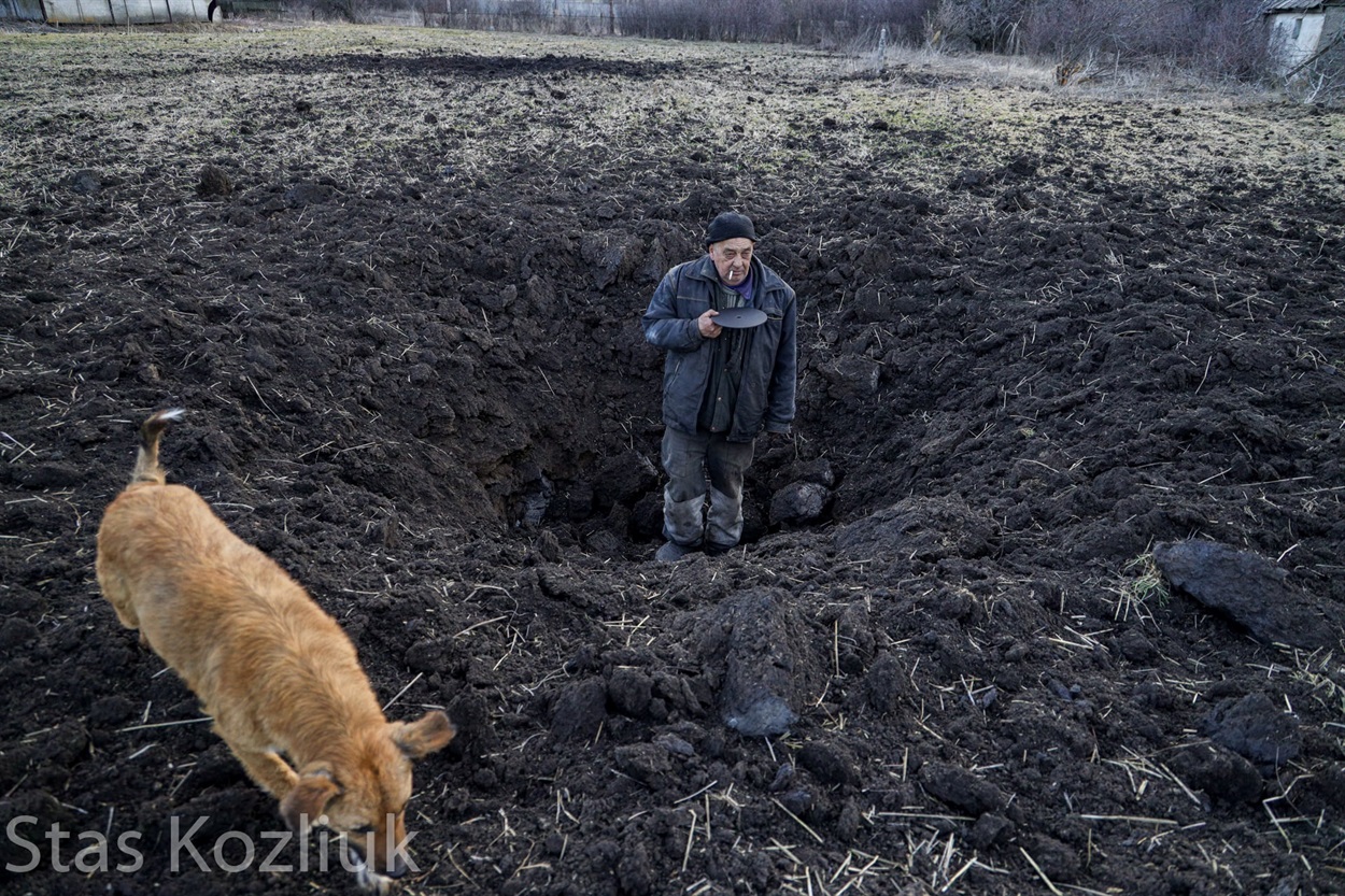 Місцевий житель у воронці від снаряду у селі Тарамчук під Мар'їнкою