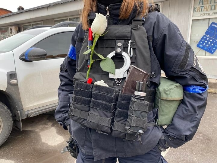 Жива біла троянда, яку маріупольці дивом знайшли та подарували співробітниці поліції, що патрулює місто.
