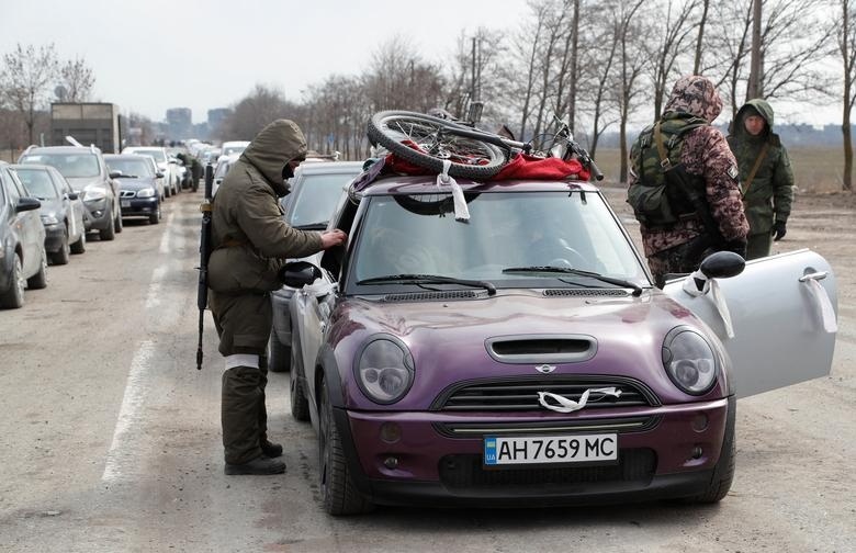 Военнослужащие российских войск проверяют автомобили на выезде из блокадного города
