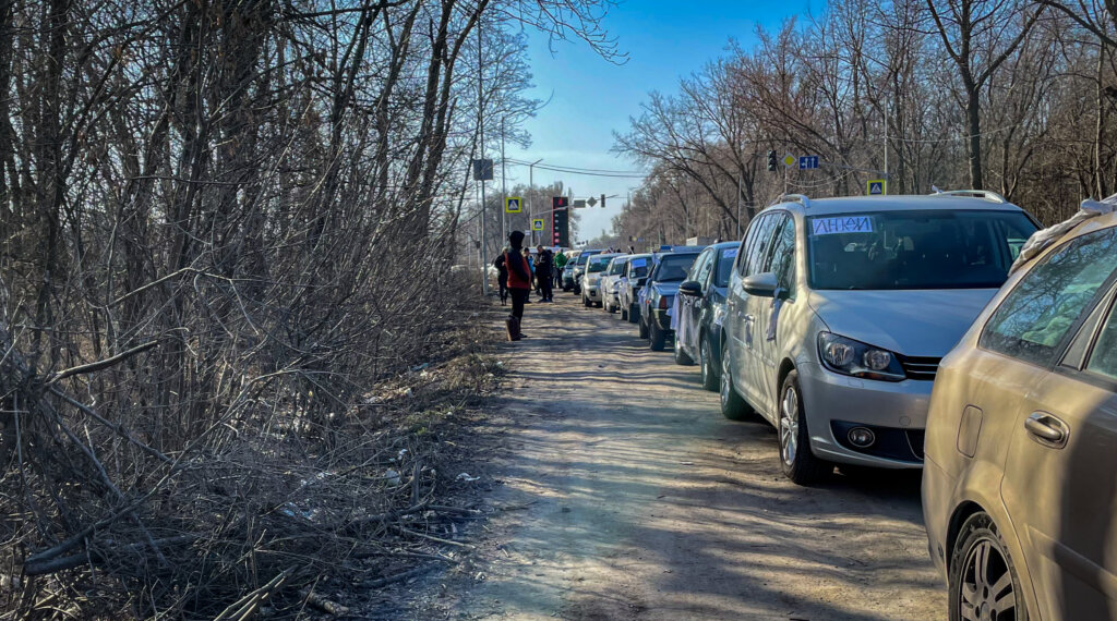 Колонны автомобилей на въезде в Мариуполь. Сюда волонтёры приезжают, чтобы забрать людей, которым удалось пешком выйти из города.