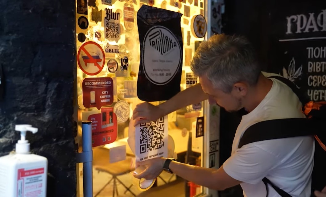 Іван вішає QR-код у кав'ярні