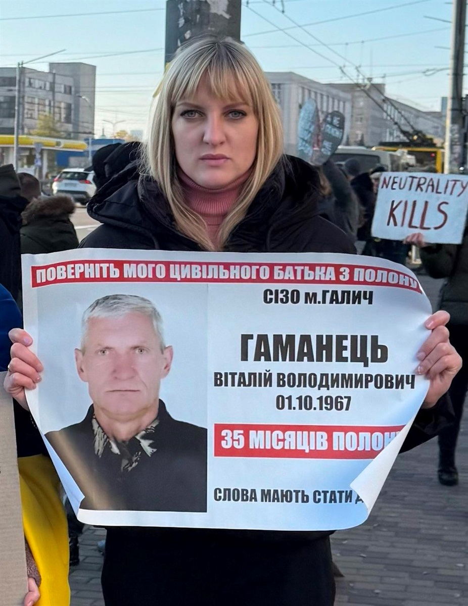 Катерина Кас'янова тримає плакат з фотографією батька, який знаходиться у російському полоні